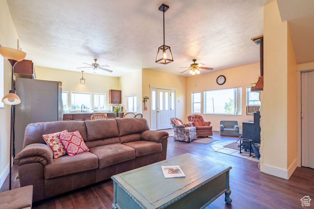 Living room with plenty of natural light, dark wood-style floors, and ceiling fan