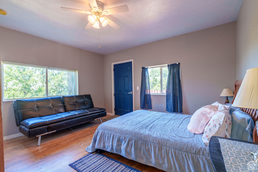 Bedroom featuring baseboards, wood finished floors, and a ceiling fan