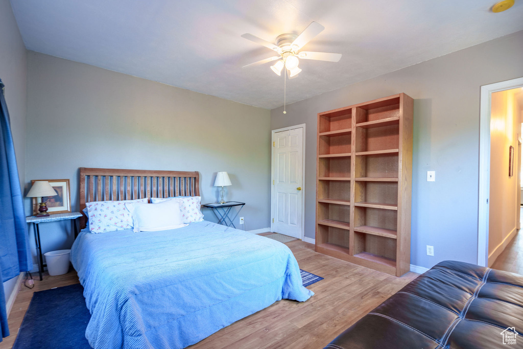 Bedroom featuring a ceiling fan, wood finished floors, and baseboards