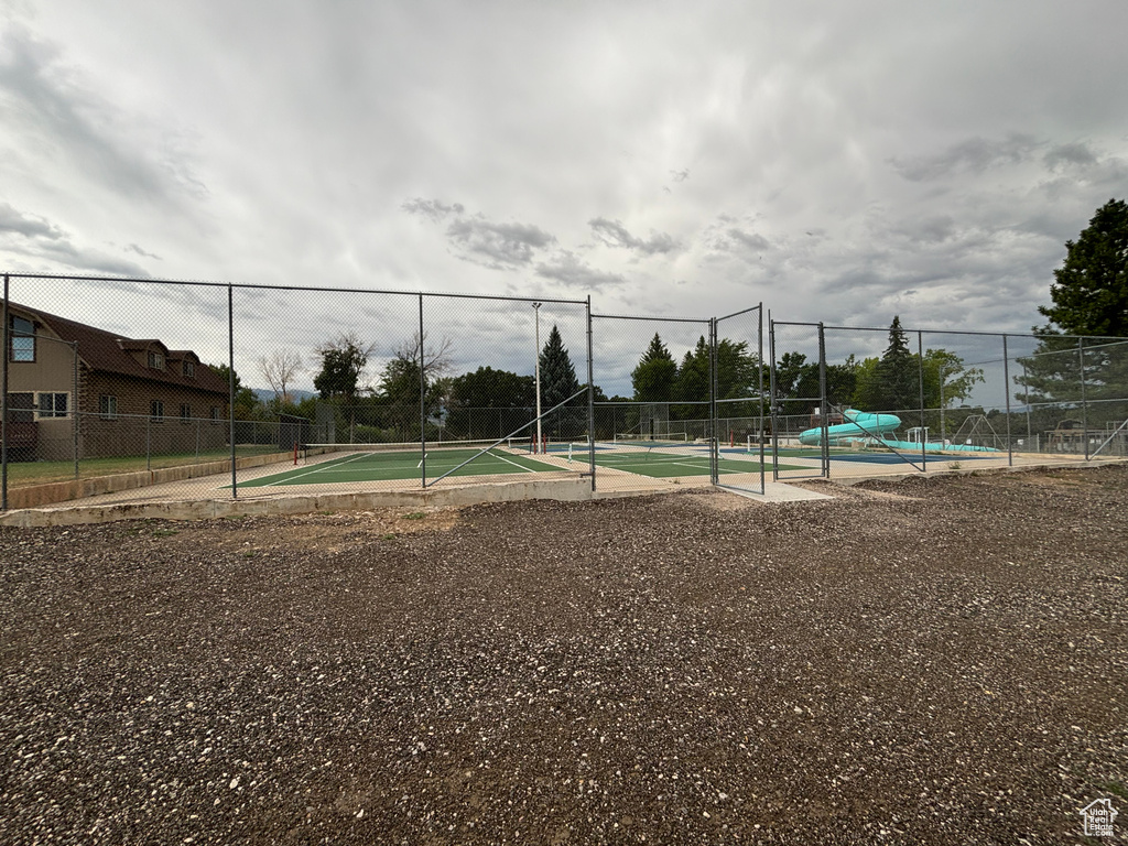 View of tennis court featuring fence