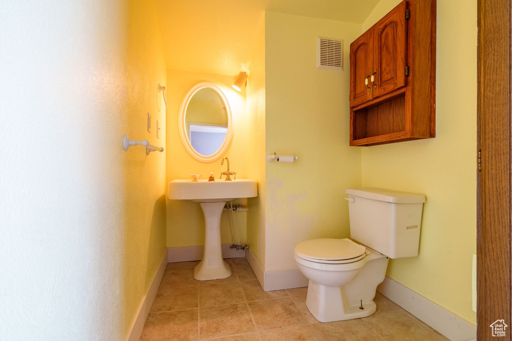 Half bath featuring tile patterned floors, visible vents, baseboards, and toilet