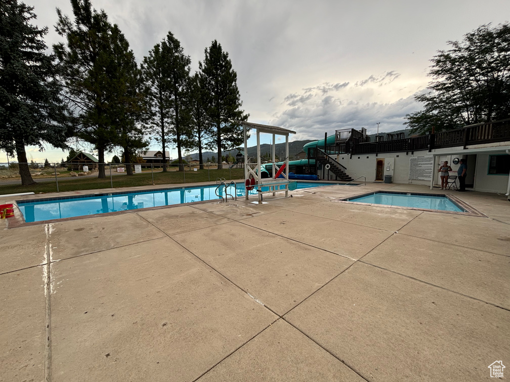 Pool featuring stairway, a patio area, and fence
