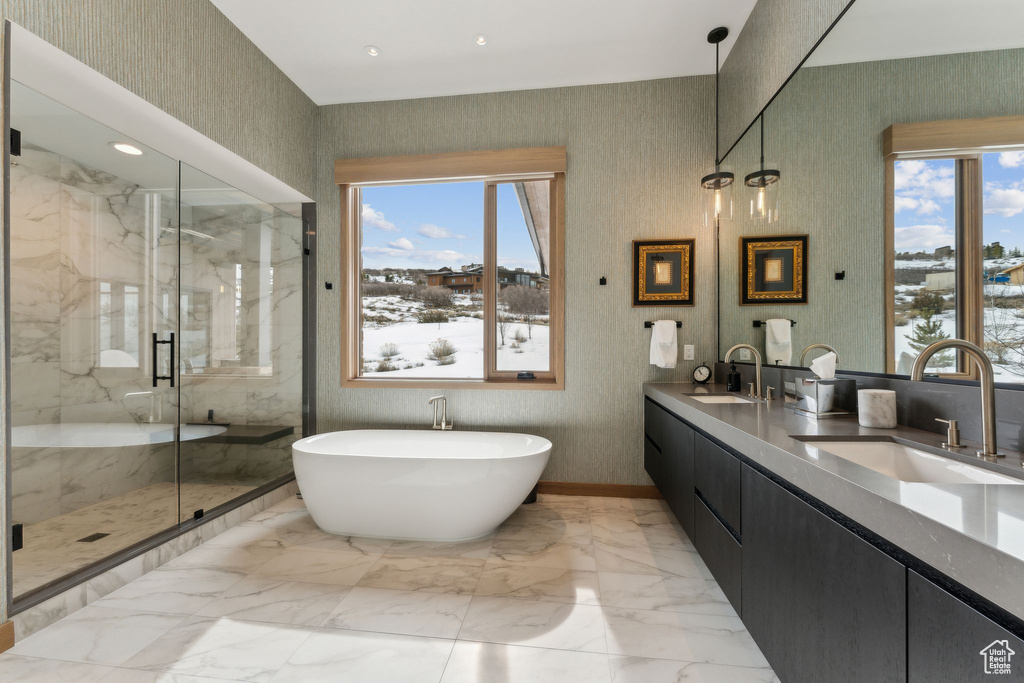 Full bath featuring plenty of natural light, marble finish floor, and a sink