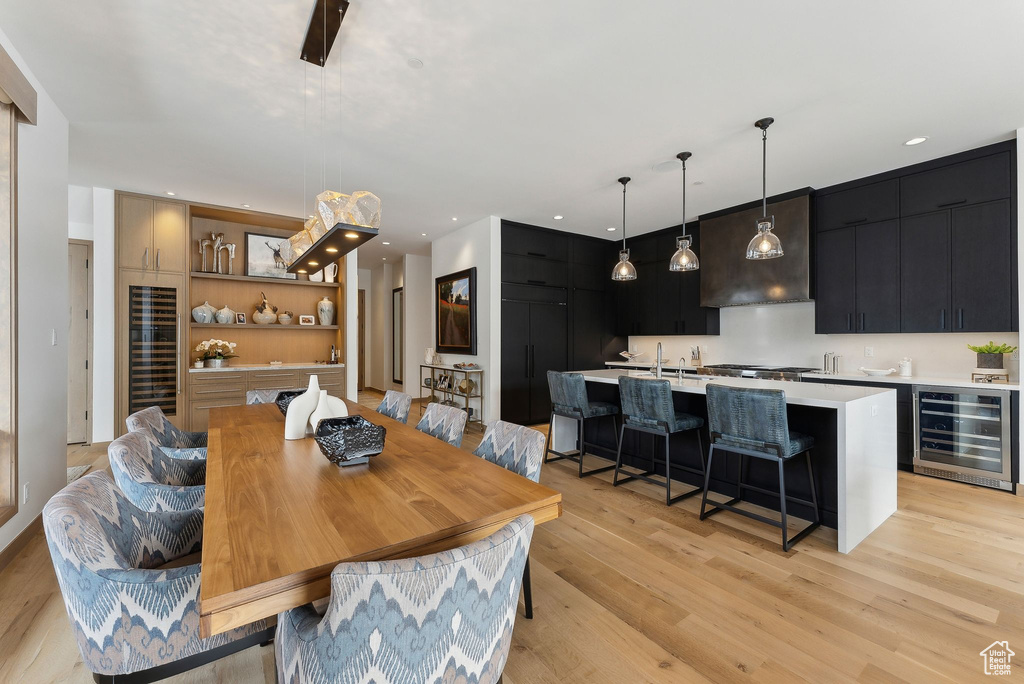 Dining area featuring recessed lighting, indoor wet bar, beverage cooler, and light wood finished floors
