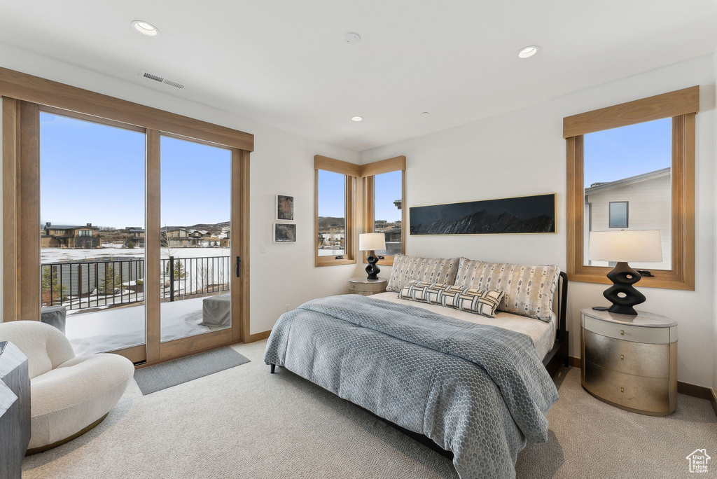 Carpeted bedroom featuring recessed lighting, visible vents, baseboards, and access to exterior