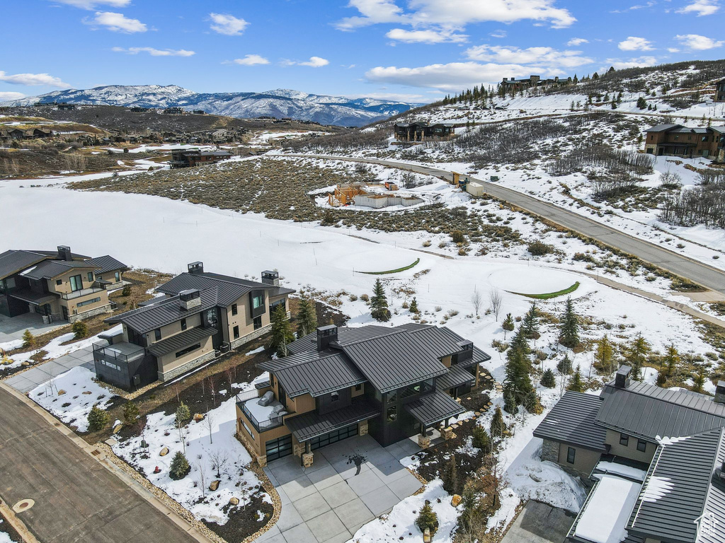 Snowy aerial view featuring a mountain view and a residential view