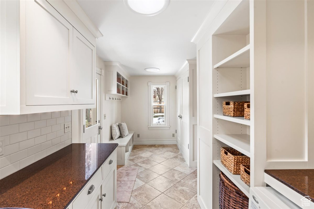 Mudroom with light tile patterned floors and baseboards