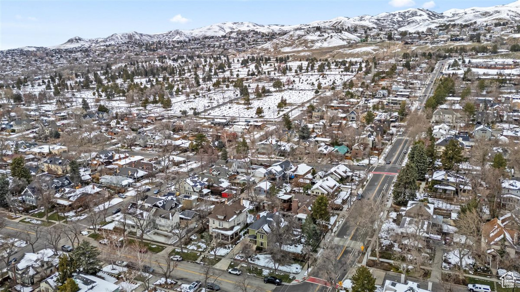 Snowy aerial view featuring a mountain view and a residential view