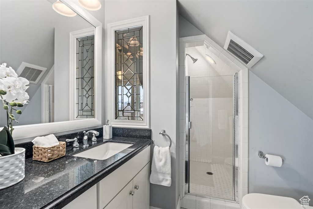 Full bathroom featuring visible vents, a shower stall, vanity, and toilet