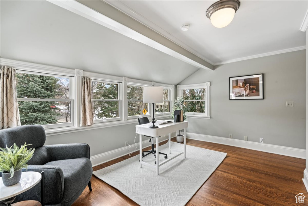 Office space with lofted ceiling with beams, crown molding, wood finished floors, and baseboards