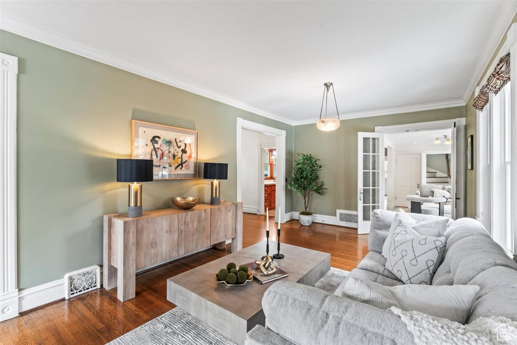 Living area with visible vents, wood finished floors, and crown molding