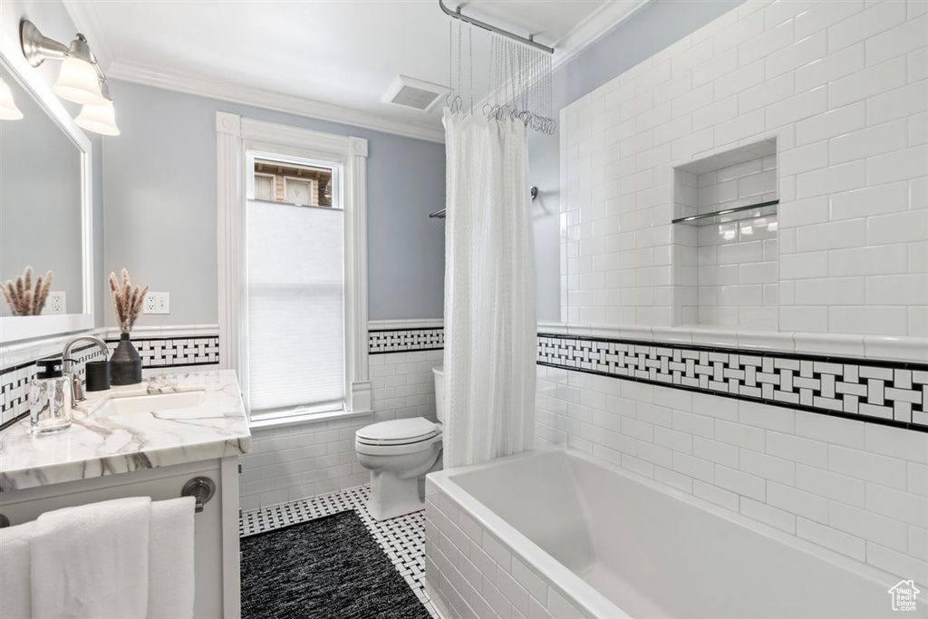 Bathroom featuring vanity, crown molding, toilet, tile walls, and tile patterned floors