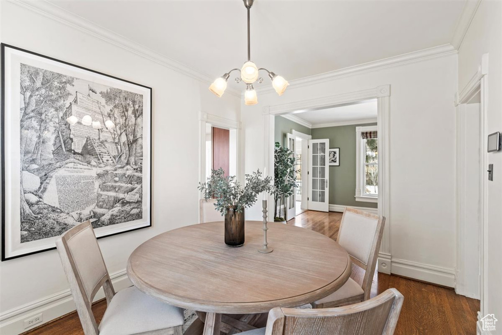 Dining space with ornamental molding, baseboards, and wood finished floors
