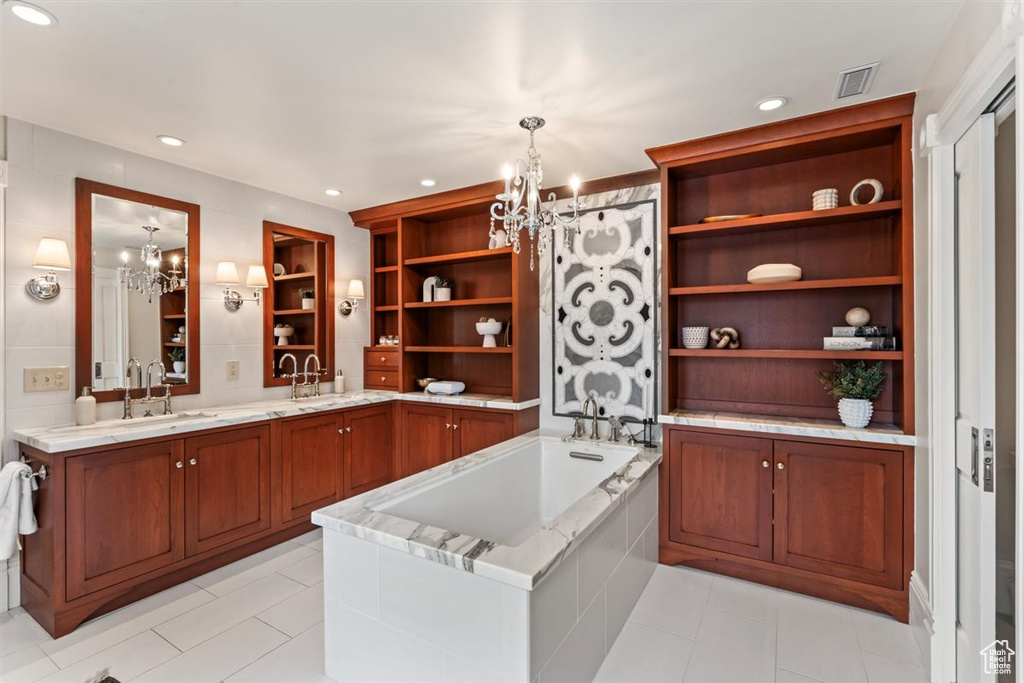 Interior space with visible vents, open shelves, decorative light fixtures, an inviting chandelier, and brown cabinetry
