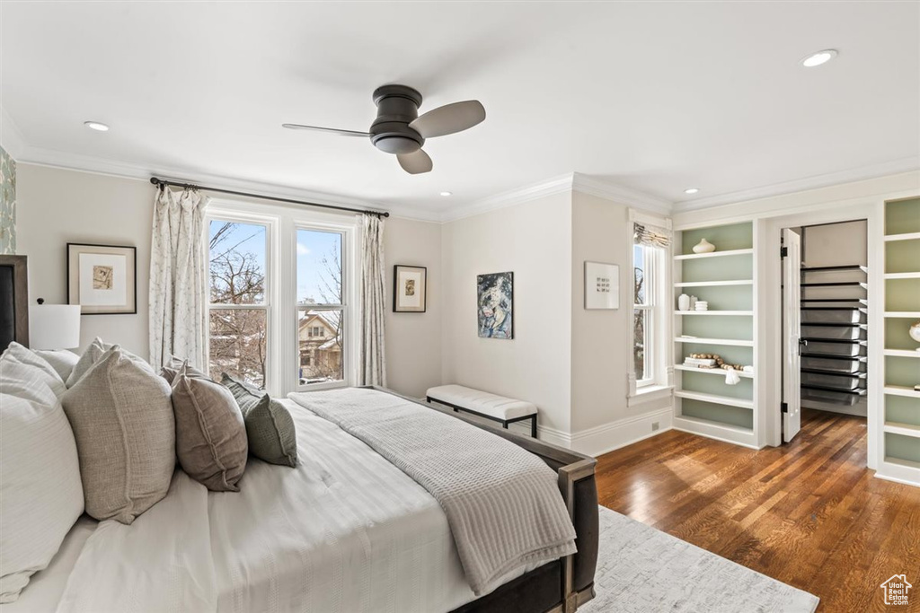 Bedroom with recessed lighting, wood finished floors, baseboards, and ornamental molding