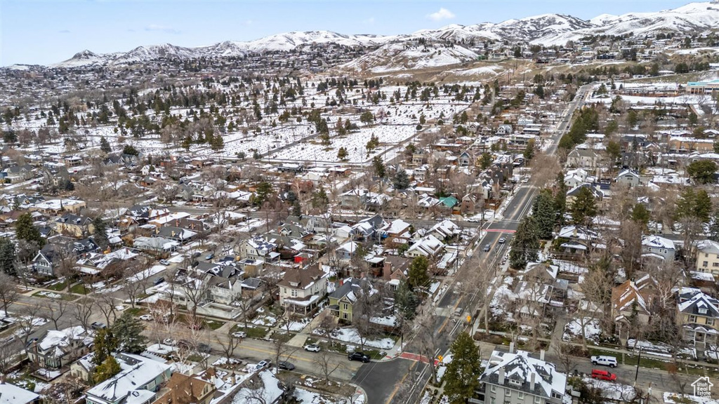 Snowy aerial view featuring a mountain view and a residential view
