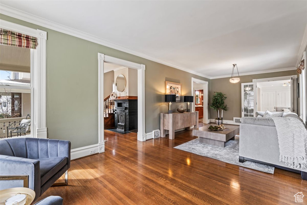 Living room with crown molding, wood finished floors, and baseboards
