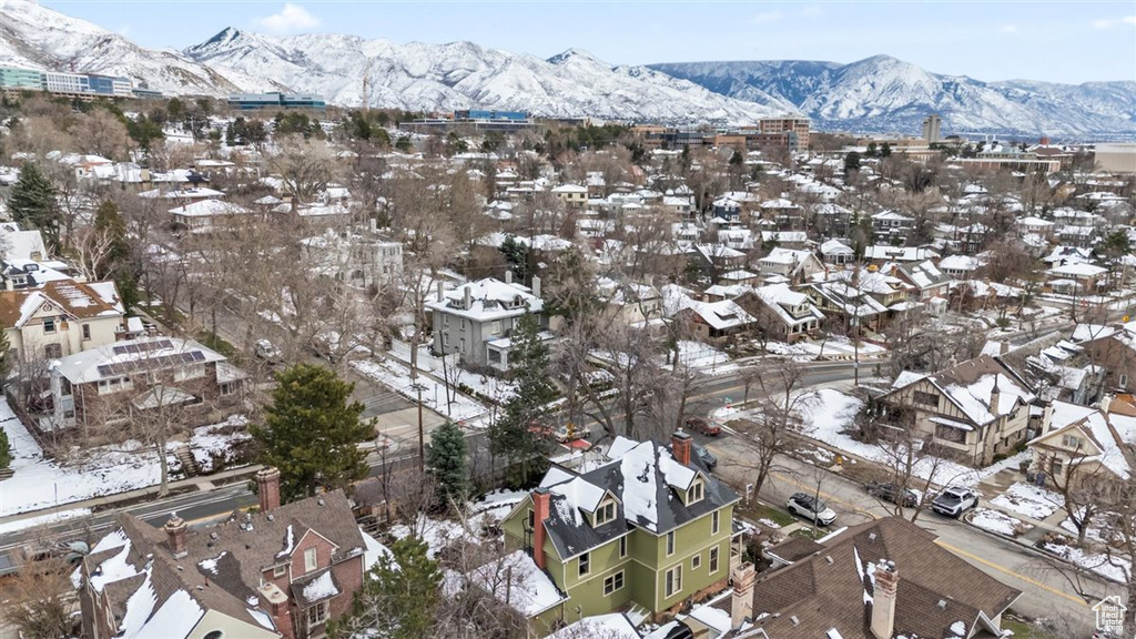 Snowy aerial view featuring a mountain view and a residential view