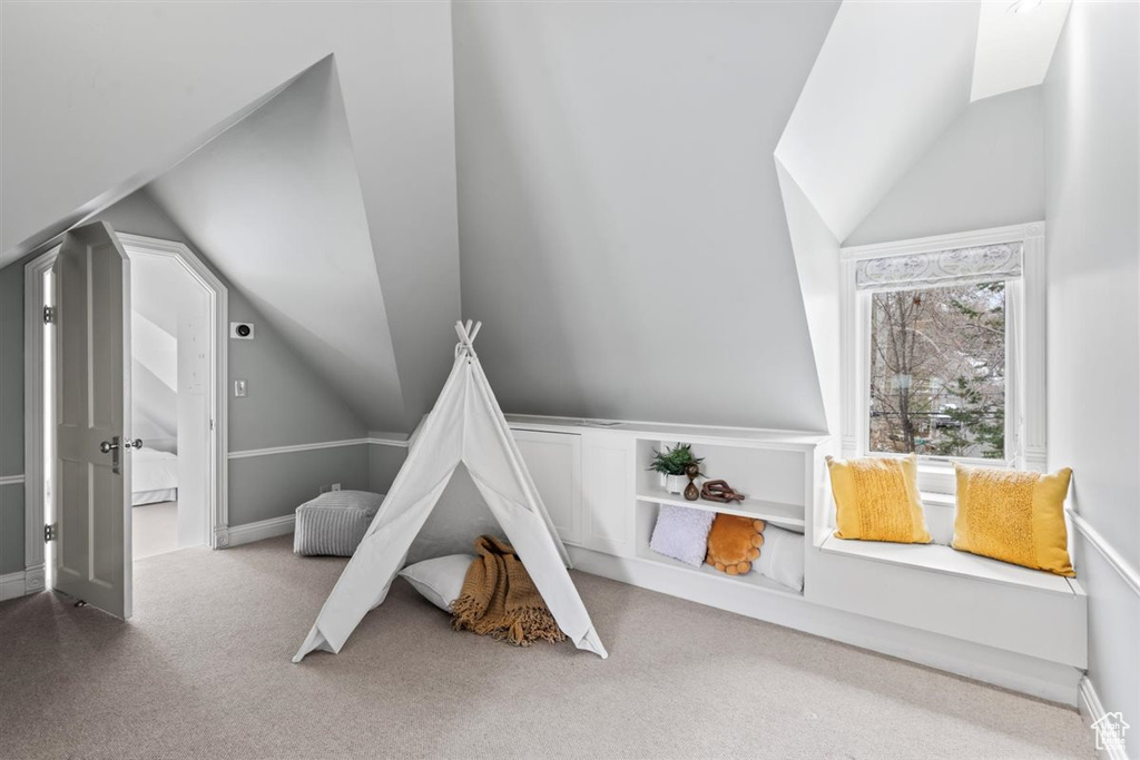 Recreation room featuring lofted ceiling, carpet flooring, and baseboards