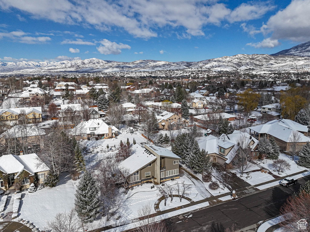 Snowy aerial view featuring a mountain view and a residential view