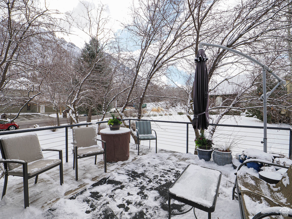 Snow covered patio featuring a balcony