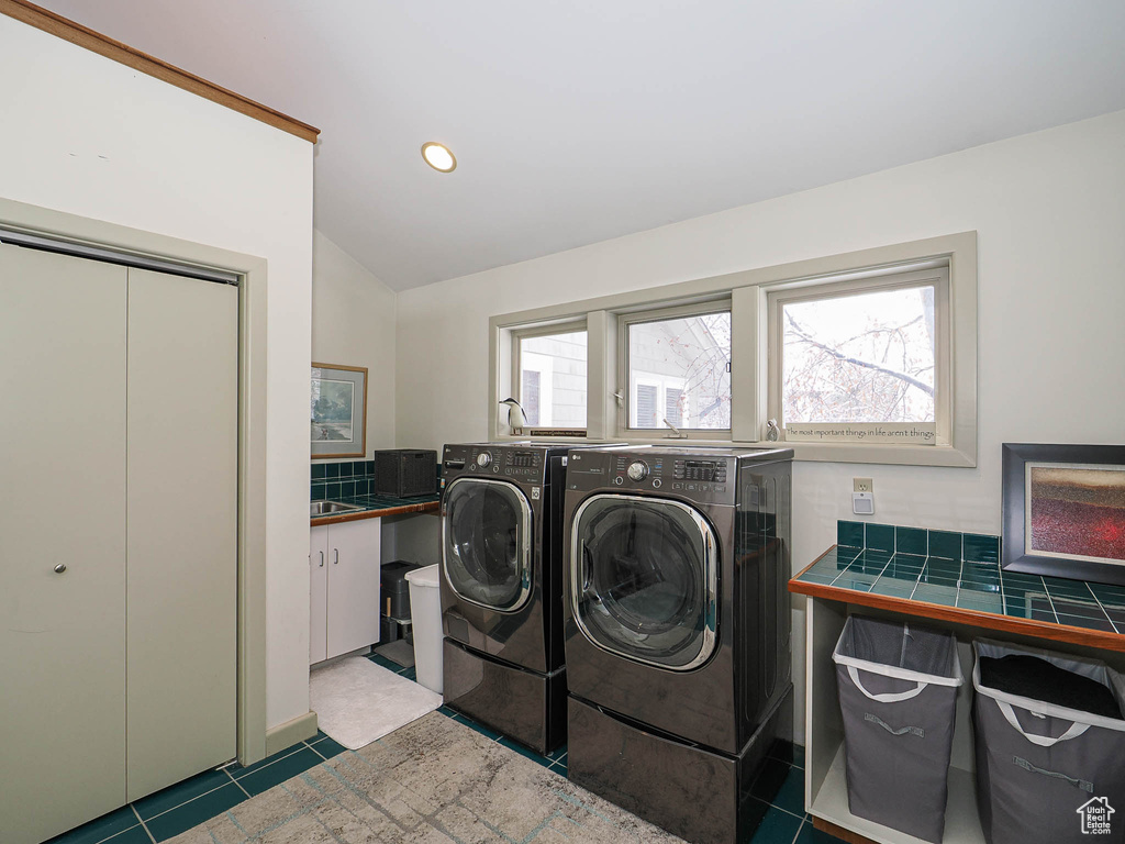 Clothes washing area featuring washing machine and clothes dryer, laundry area, tile patterned flooring, and recessed lighting