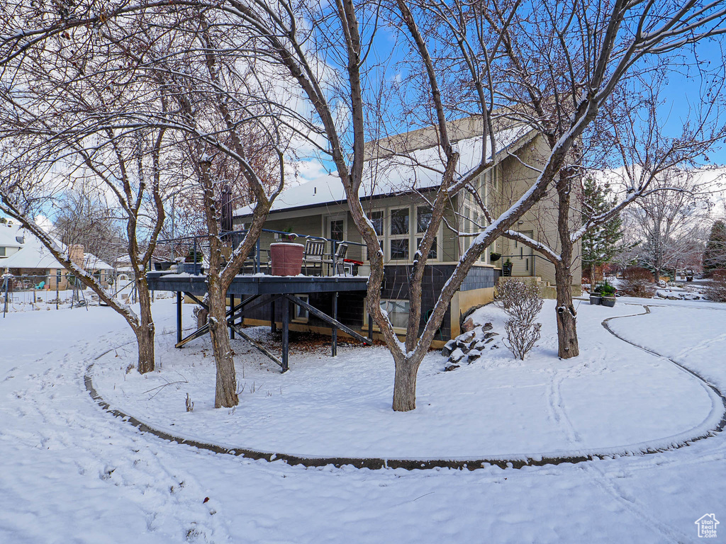 Snow covered property with stairway and a wooden deck