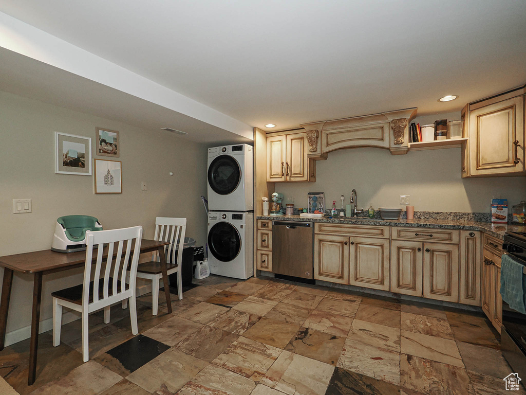 Kitchen with a sink, recessed lighting, appliances with stainless steel finishes, and stacked washer and dryer