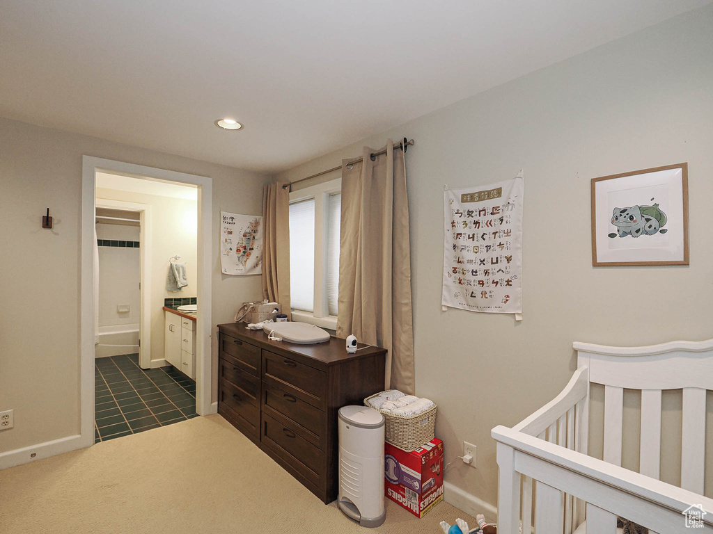 Bedroom with connected bathroom, baseboards, recessed lighting, a nursery area, and dark colored carpet
