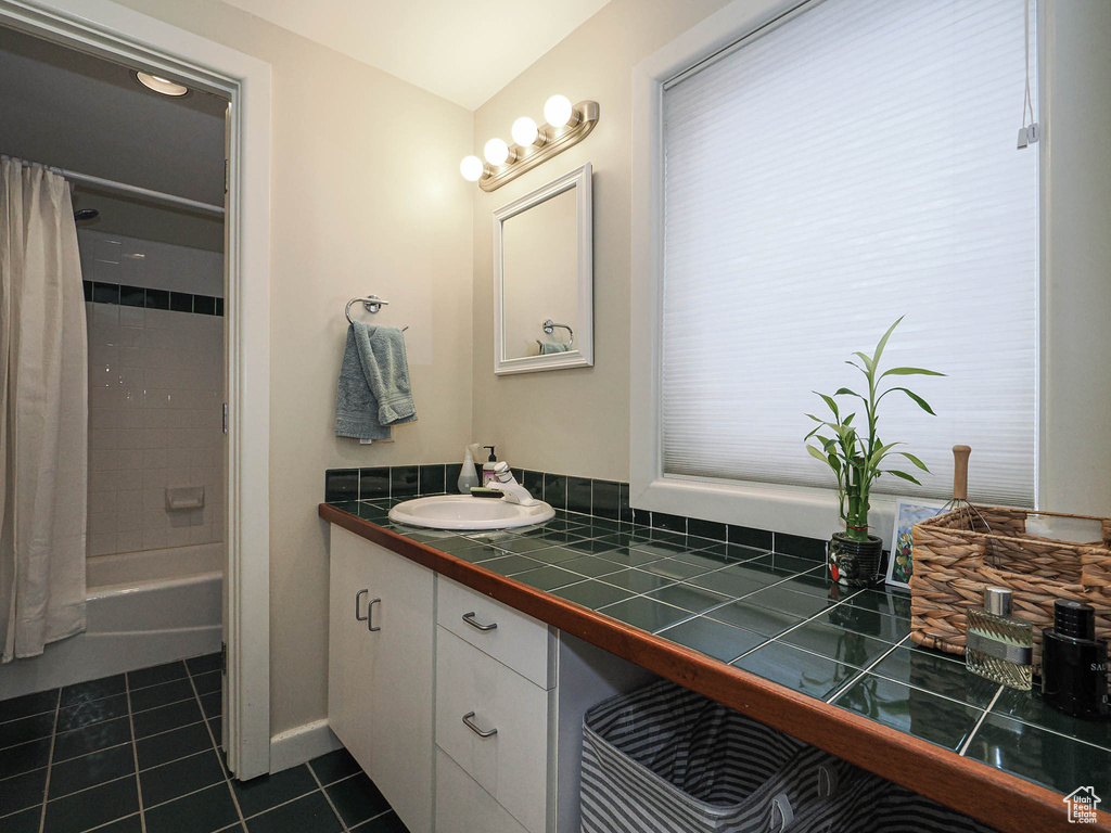 Full bathroom with tile patterned floors, vanity, and shower / bathtub combination with curtain