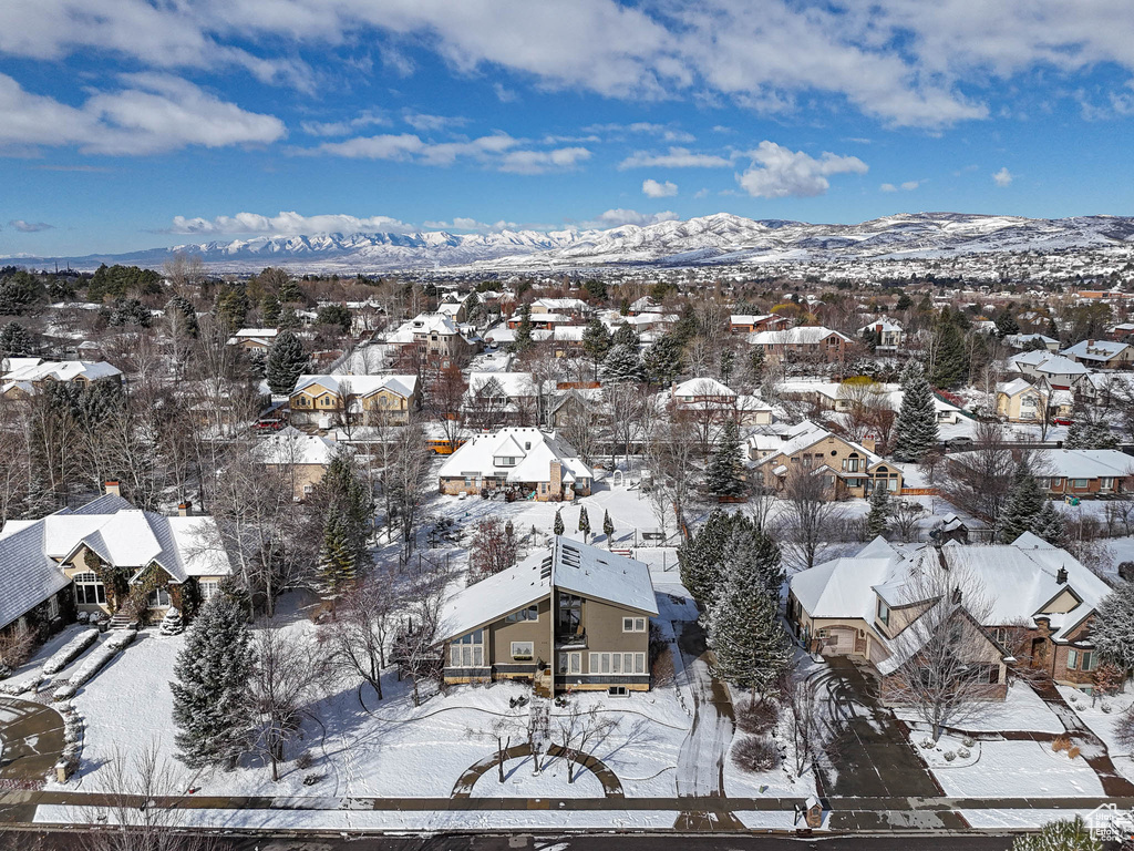 Snowy aerial view featuring a residential view and a mountain view