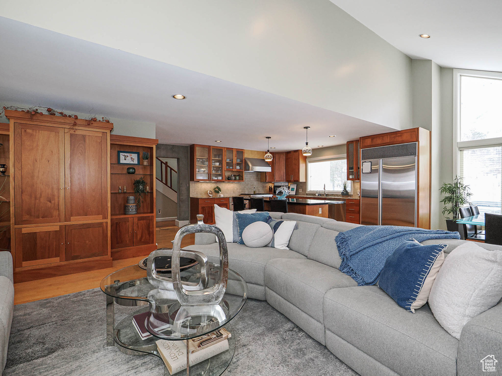 Living area featuring light wood finished floors, recessed lighting, and stairs