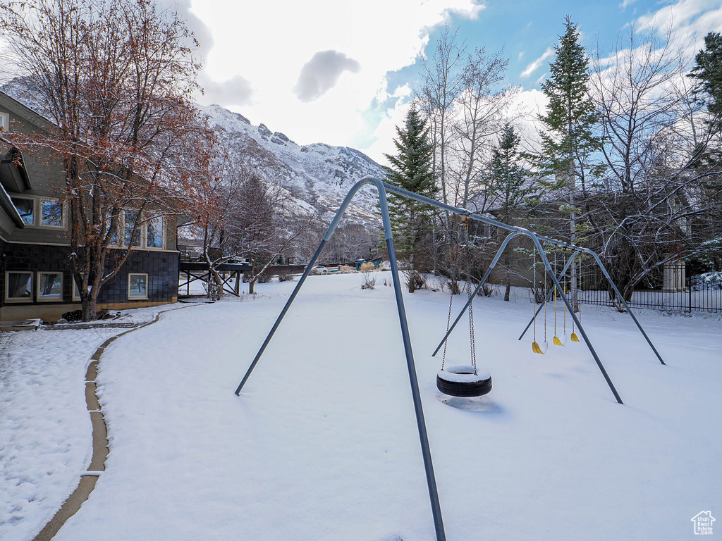 Yard layered in snow featuring a mountain view