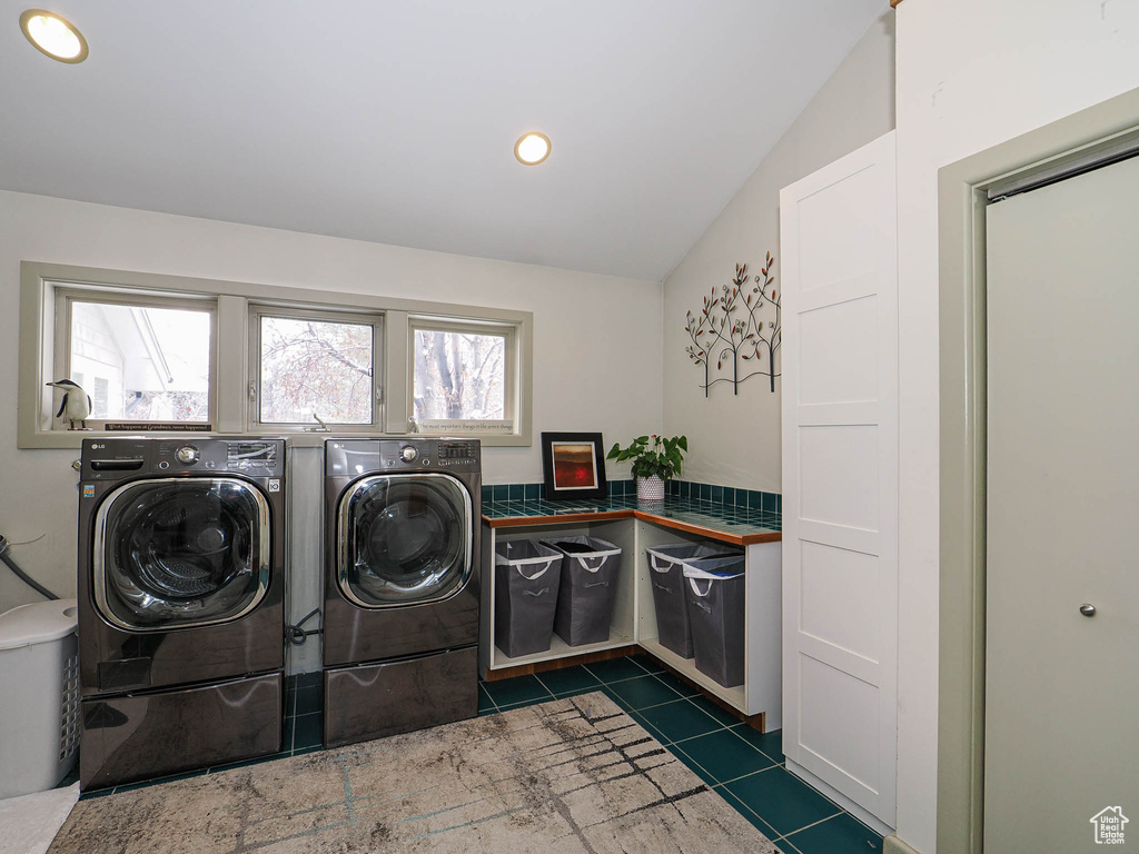 Washroom featuring washing machine and clothes dryer, laundry area, recessed lighting, and dark tile patterned floors