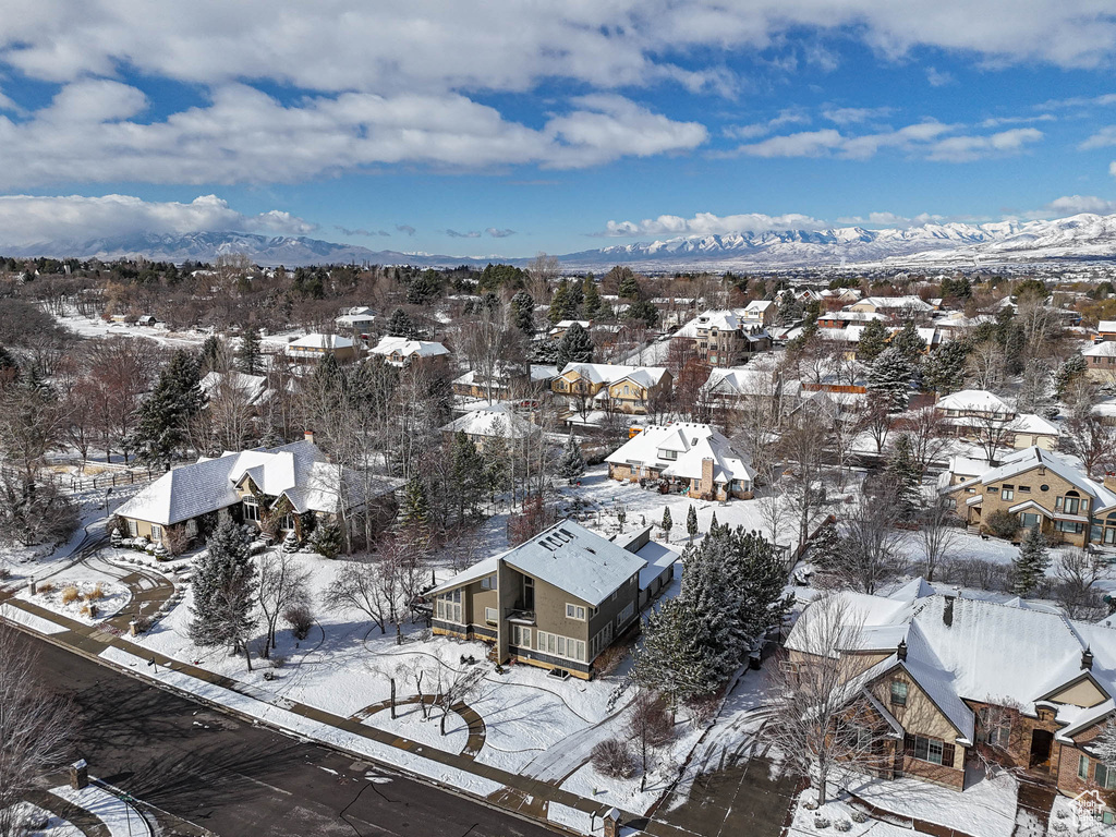 Snowy aerial view featuring a mountain view and a residential view