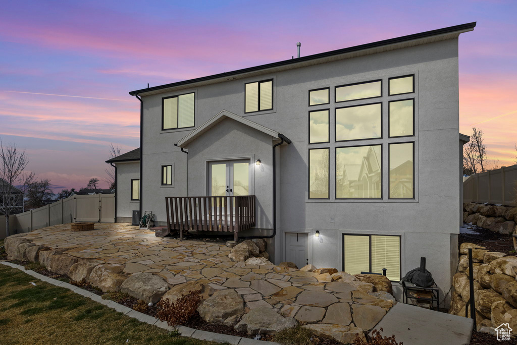 Rear view of house featuring stucco siding, a patio area, french doors, and a fenced backyard