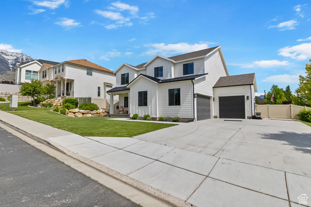 View of front of house with board and batten siding, concrete driveway, and a garage