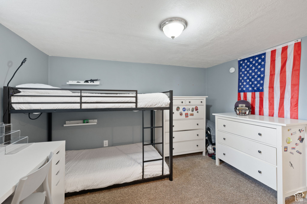 Bedroom featuring light colored carpet and a textured ceiling