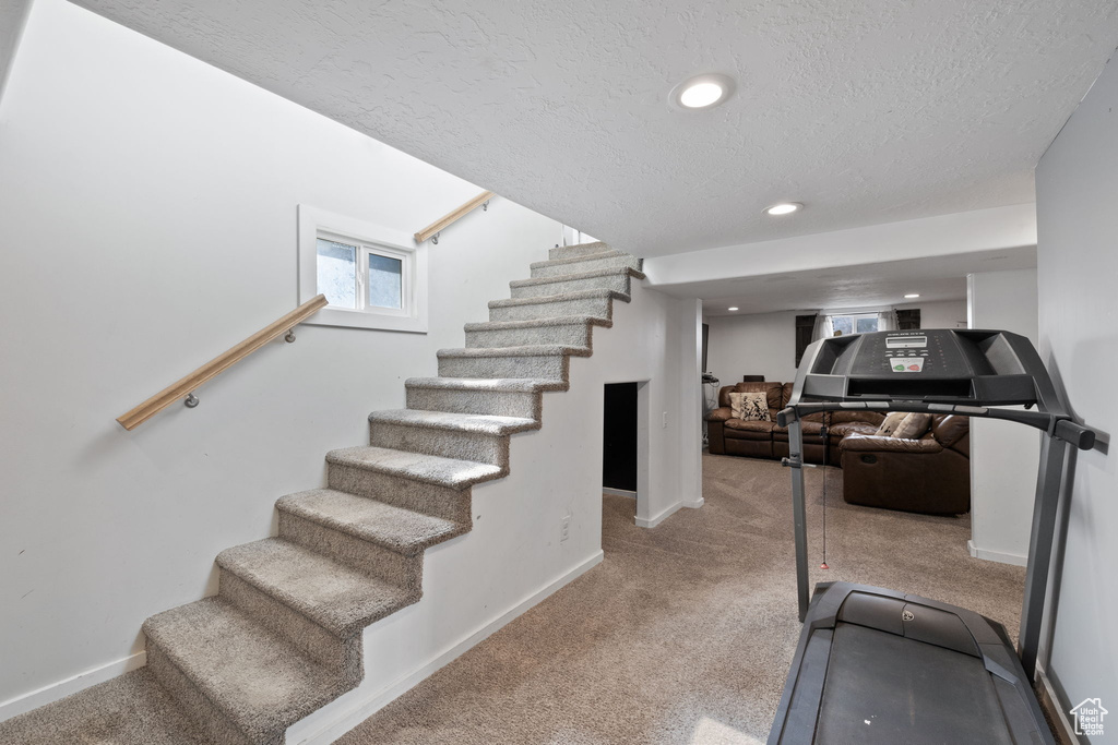 Exercise area with carpet flooring, recessed lighting, baseboards, and a textured ceiling