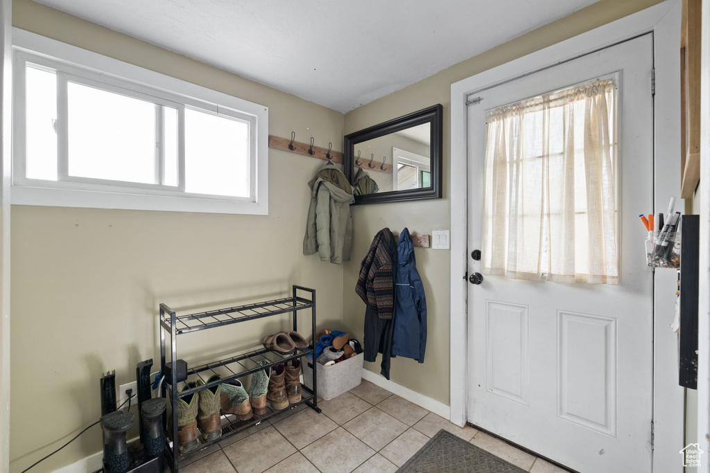 Doorway featuring tile patterned floors and baseboards