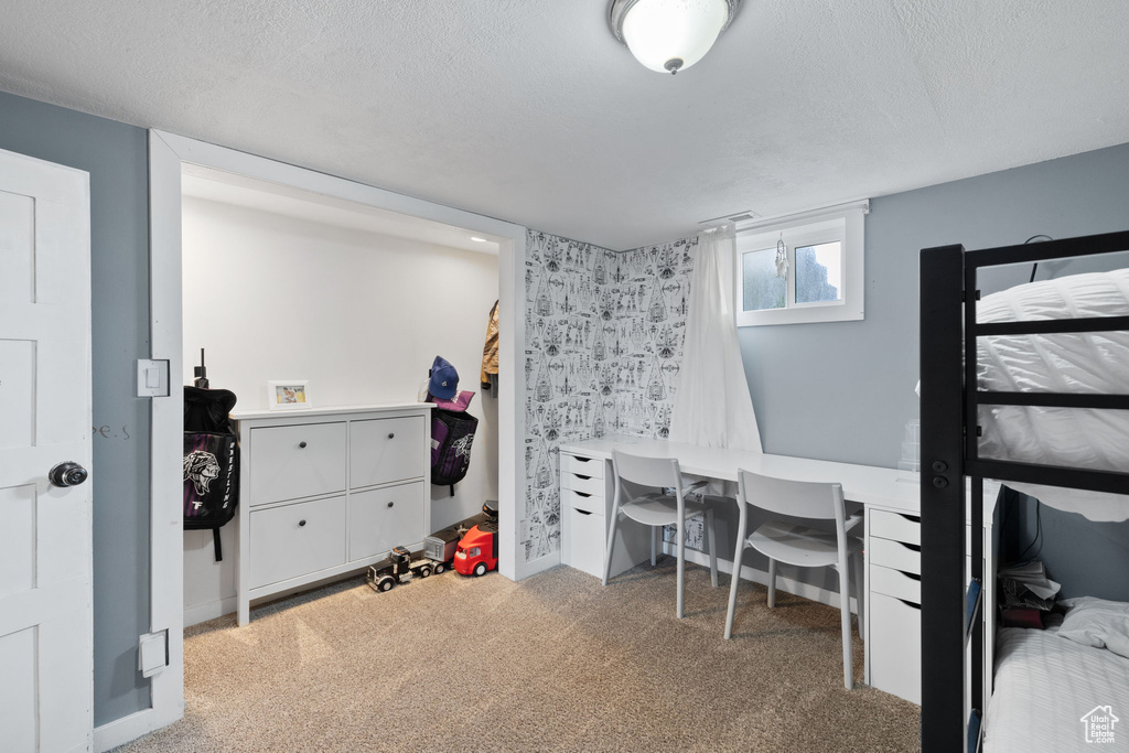 Bedroom featuring carpet flooring and a textured ceiling