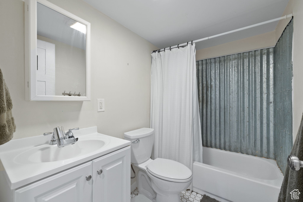 Full bathroom featuring toilet, vanity, and shower / tub combo