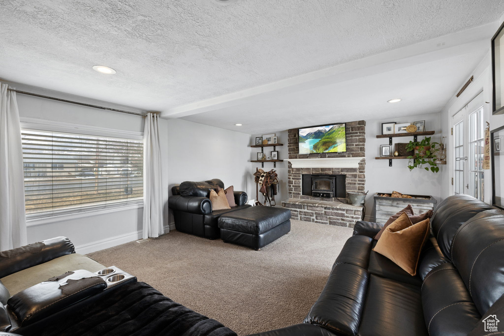 Living room featuring a brick fireplace, baseboards, carpet floors, recessed lighting, and a textured ceiling