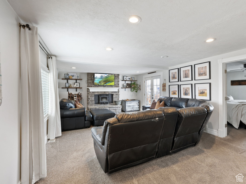 Living area featuring recessed lighting, light carpet, a textured ceiling, and a fireplace