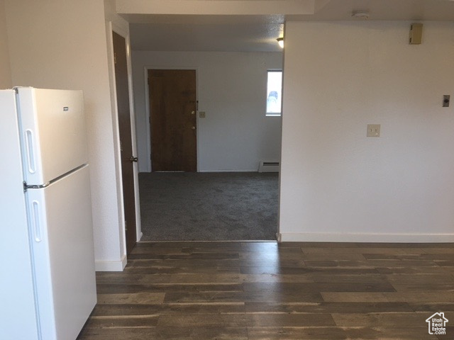 Interior space with baseboards, baseboard heating, and wood finished floors
