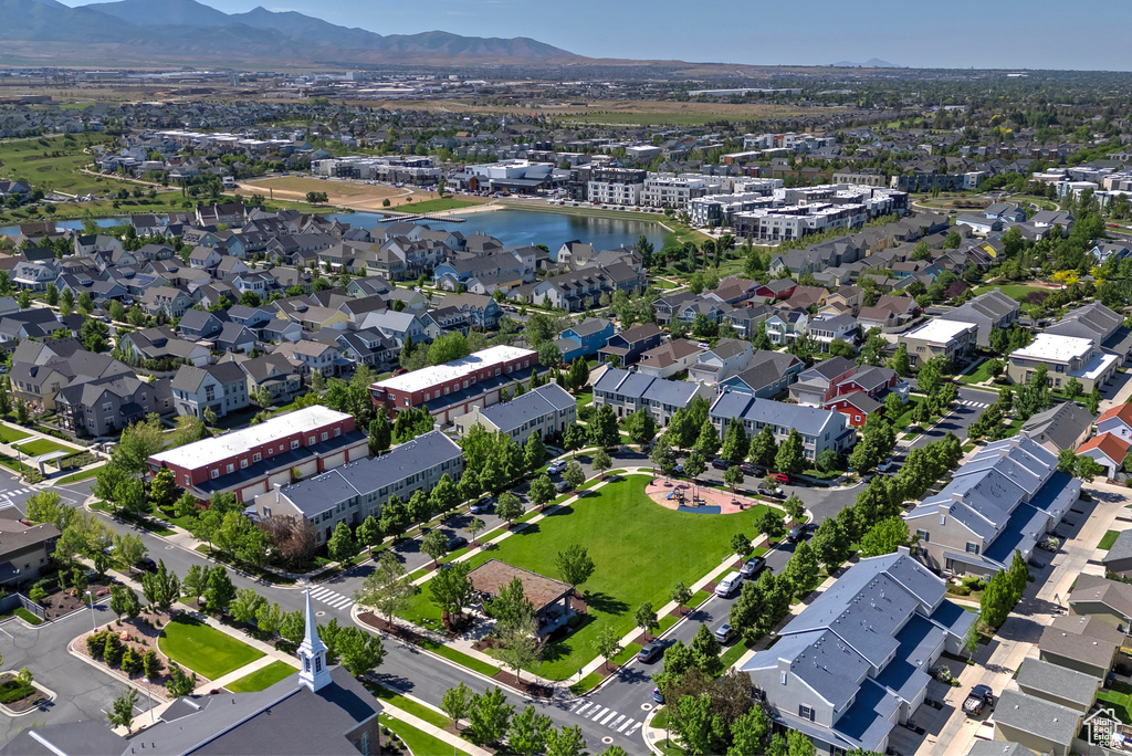 Aerial view of property and surrounding area with a water and mountain view and nearby suburban area