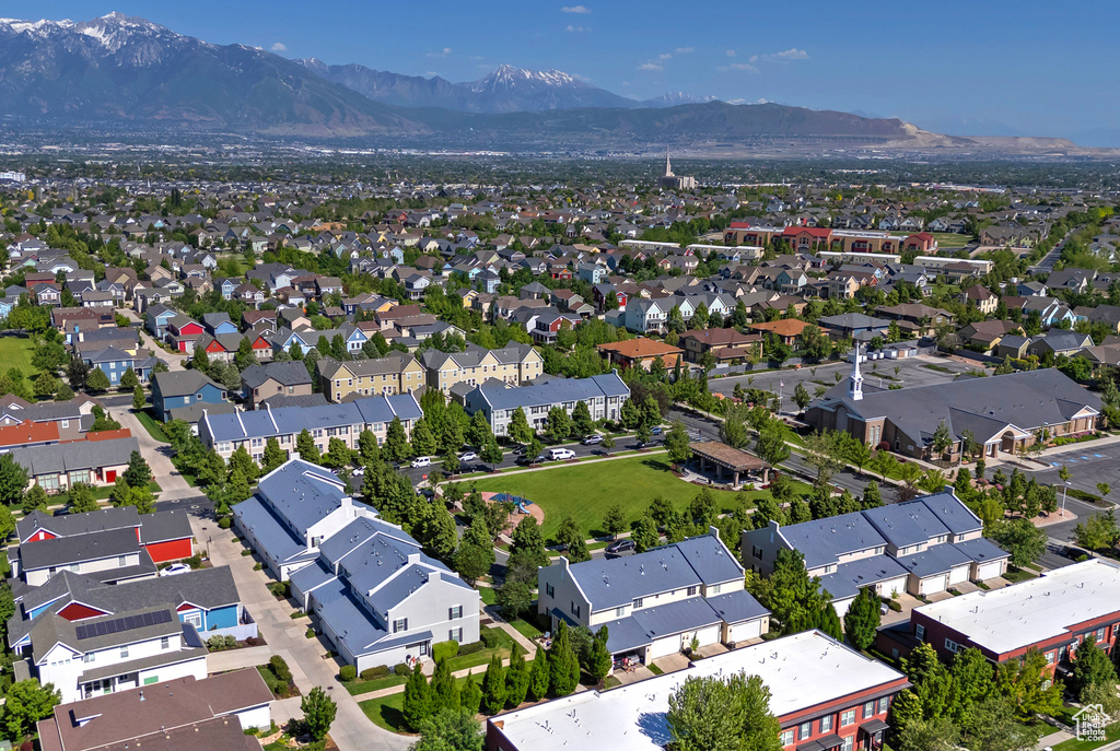 Aerial view of property and surrounding area with mountains and nearby suburban area