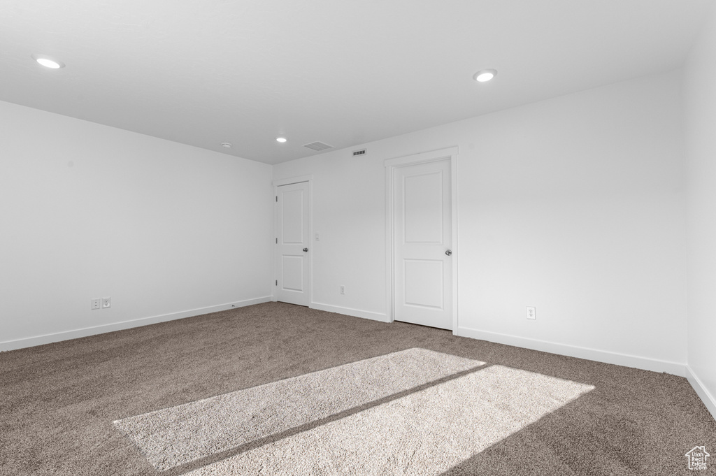 Carpeted empty room with visible vents, recessed lighting, and baseboards