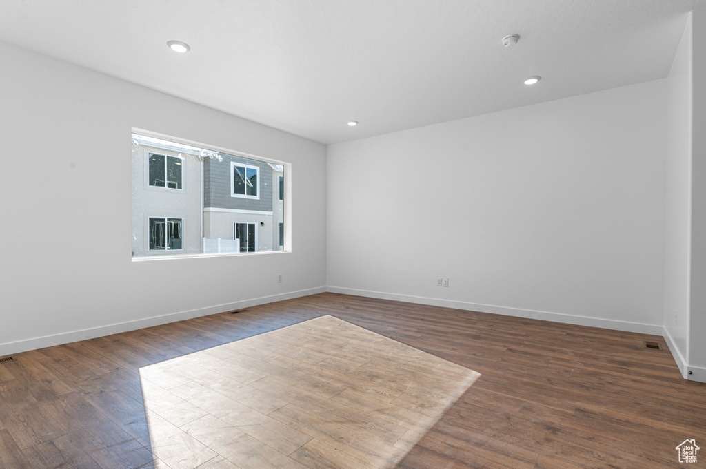 Empty room with recessed lighting, baseboards, and dark wood-style flooring