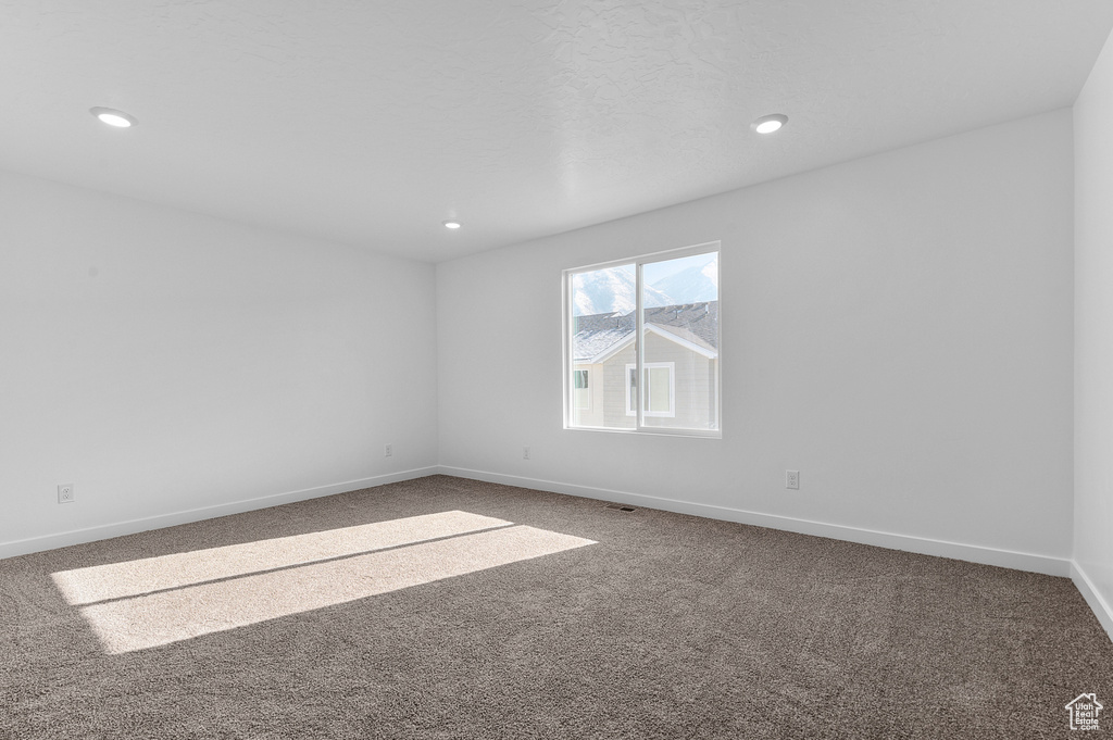 Carpeted spare room featuring recessed lighting and baseboards